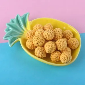 Macro detail of 16mm yellow crochet cotton balls for DIY jewelry accessories in a tray