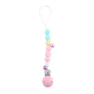 Detail of macaron silicone pacifier clip with purple bells and pink safety clasp