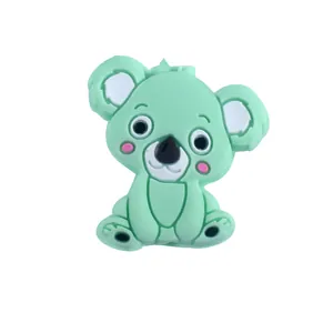 Détail macro d'une perle en silicone koala vert menthe avec traits de dessin animé