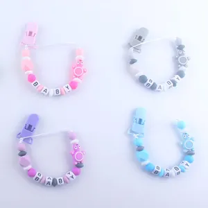 Detalle de sujetachupetes de silicona con cuentas coloridas y bloques de letras BABY