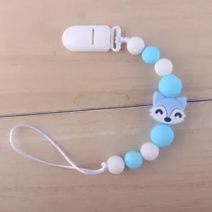 Close-up of baby silicone pacifier clip with blue fox bead and white plastic fastener