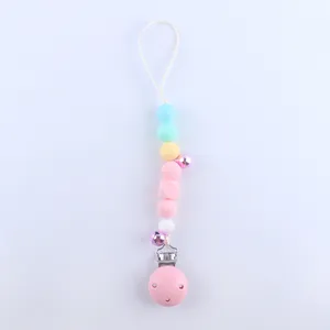 Detail of macaron-colored silicone pacifier clip with purple bells and plastic clip