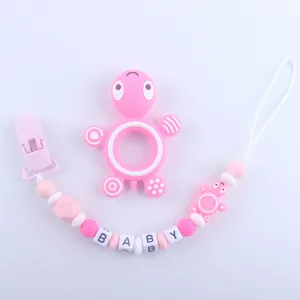 Close-up of pink turtle silicone teether set with pacifier clip and BABY letter beads