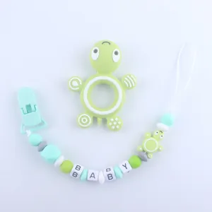Detailed view of turtle teething toy and silicone pacifier clip with baby letter beads