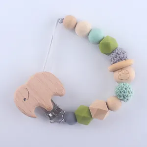 Detail of wooden elephant clip and silicone beads on infant pacifier tether strap