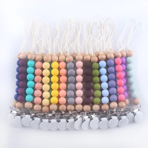 Detailed row of colorful silicone and wooden baby pacifier clips in various pastel tones