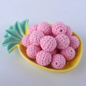 Detail of pink 20mm crochet cotton beads on a yellow tray for DIY jewelry making