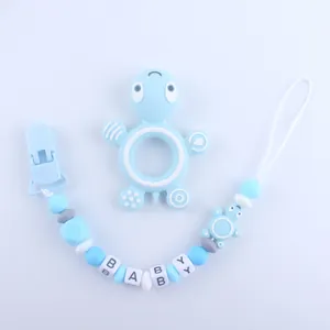 Close-up of baby silicone turtle teether with a beaded pacifier clip chain spelling BABY