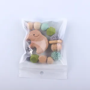 Detailed view of silicone pacifier clip with wooden elephant and colorful beads in bag