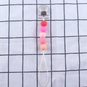 Detailansicht des Schnullerkettenhalters mit Silikonperlen und Metallclip auf Karomuster