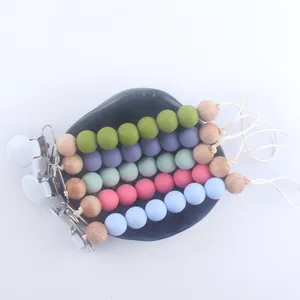 Five assorted silicone and wood bead pacifier clips in pastel colors for infants