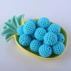 Macro detail of 20mm blue hand-crocheted cotton yarn beads for DIY jewelry making