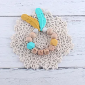 Détail de l'attache-tétine en bois de hêtre et silicone avec perles et lettres BABY