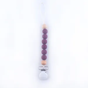 Detail of baby silicone pacifier clip with purple beads and natural wooden pearls