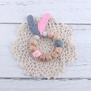 Attache-tétine en bois de hêtre et silicone avec plumes et perles de lettres en bois