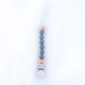 Detail view of baby pacifier clip with grey silicone beads and natural wooden accents