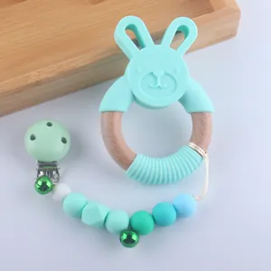 Silicone rabbit teething ring and matching pacifier clip with bells in mint green