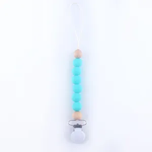 Detail of baby pacifier clip with blue silicone beads and natural wooden beads