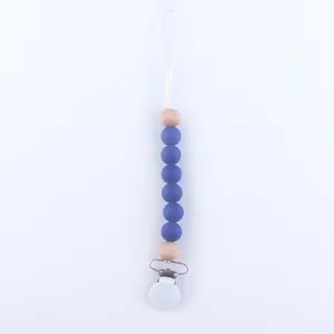 Detail of baby pacifier clip with blue silicone beads and natural wooden accents