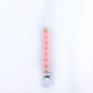 Detail of pink silicone beads and wooden clip on a baby pacifier chain accessory
