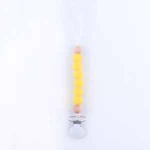 Detail of baby pacifier clip with yellow silicone beads and natural wooden beads