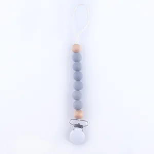 Detail of baby pacifier clip with grey silicone beads and natural wooden accents