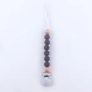 Detail of baby silicone pacifier clip with wood beads and metal safety buckle fastener