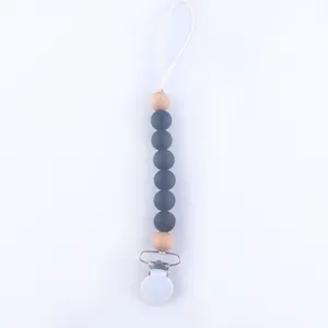 Close-up of baby pacifier clip with grey silicone beads and natural wooden accents