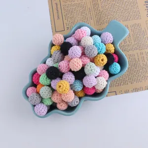 Assorted 16mm crochet cotton thread beads in a ceramic tray for DIY jewelry making