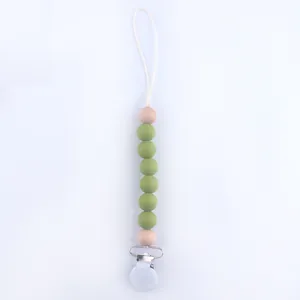 Detail of green silicone and wood beads on a baby pacifier clip with a metal fastener