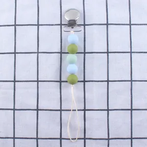 Baby Schnullerkette aus Silikon mit bunten Perlen und Metallclip auf blauem Karostoff