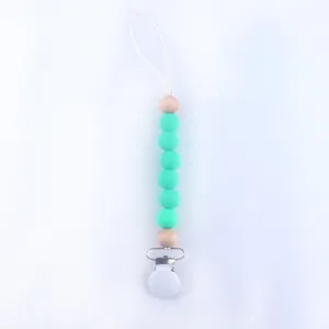 Detail of mint green silicone and wood bead baby pacifier clip with secure plastic fastener