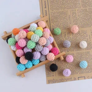Handmade 16mm cotton crochet beads in vibrant mixed colors on a rustic wooden tray