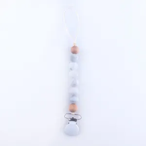 Detail of baby pacifier clip with marble texture beads and natural wooden accents