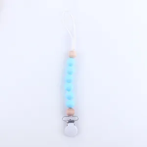 Detail of baby silicone pacifier clip with sky blue beads and natural wood accents