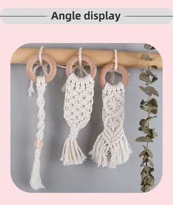 Close-up of bohemian hand-woven cotton ropes with natural wooden rings for babies