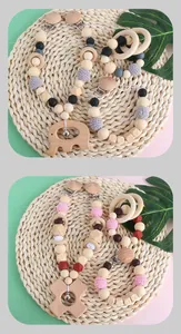 Close-up of wooden baby pacifier chain with silicone beads and crochet elephant rattle