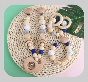 Detailed view of wooden whale teether and silicone pacifier chain on a woven mat