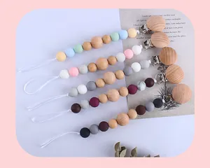 Detail of five silicone and beech wood pacifier clips with various color bead combinations
