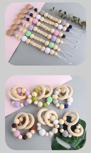 Close-up of baby pacifier clip and wooden teething ring with crochet and silicone beads