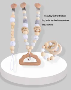 Detail showing wooden baby teething set with beaded pacifier clips and metal bell ring