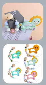 Detail of baby silicone lion teether with matching beaded pacifier clip and wooden clip