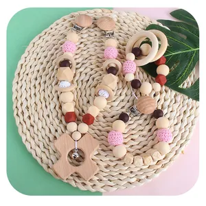 DIY baby pacifier clip and wooden teether set with pink crochet beads on woven mat