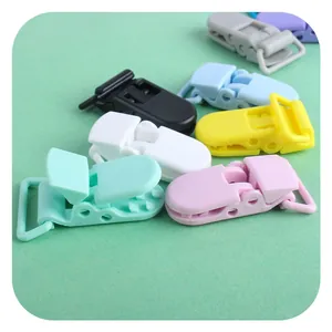 Clip per ciuccio in plastica multicolore per accessori fai-da-te su sfondo pastello