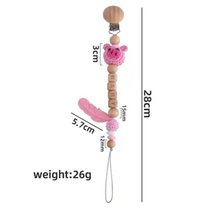 Pink crochet pig pacifier clip with baby beads and silicone feather teething toy