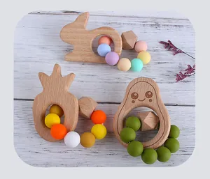 Detailed close-up of beech wood and silicone baby teething rings in rabbit and fruit shapes
