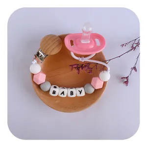Pink silicone baby pacifier and personalized wooden clip chain with letter beads