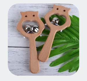 Détail de deux hochets bébé en forme de chouette en bois de hêtre naturel avec grelots