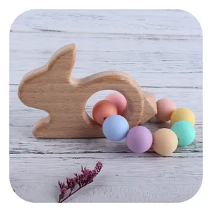 Eco-friendly beech wood rabbit teether with macaron silicone beads on wooden floor