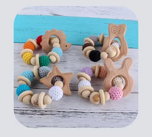 Macro detail of natural beech wood baby rattle and silicone crochet bead teething ring